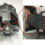 Carbon brushes contacting motor armature in washing machine motor assembly