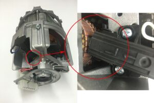 Carbon brushes contacting motor armature in washing machine motor assembly